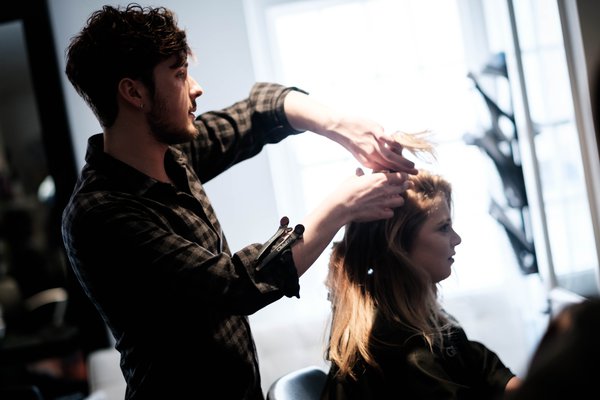 Apprentice styles woman's hair